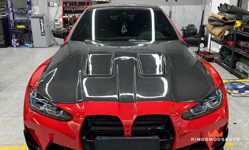 Carbon fiber vented hood fitted to a red BMW G8X M3/M4, front view
