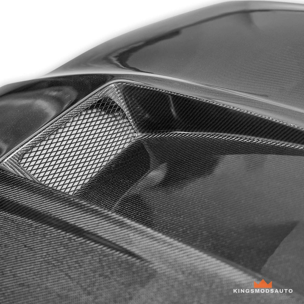 Close-up of a hood vent with its mesh insert and the carbon weave around it